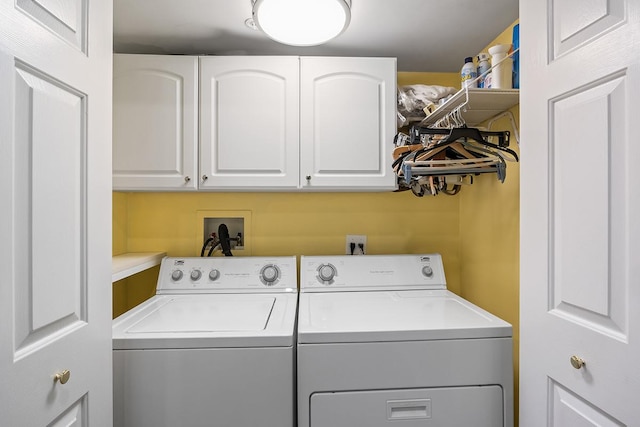 clothes washing area featuring cabinets and washing machine and dryer