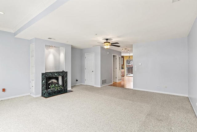 unfurnished living room with carpet, ceiling fan, and a premium fireplace