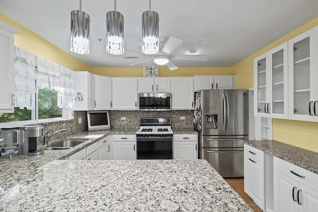 kitchen featuring pendant lighting, sink, white cabinetry, and stainless steel appliances