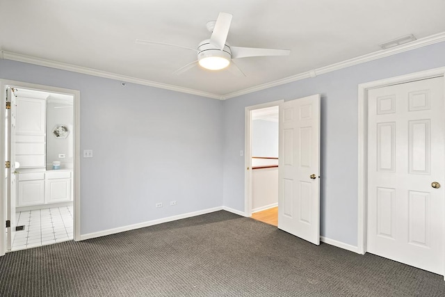 unfurnished bedroom with dark colored carpet, ceiling fan, crown molding, and ensuite bath