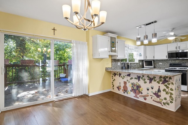 kitchen with kitchen peninsula, white range oven, white cabinets, and hanging light fixtures