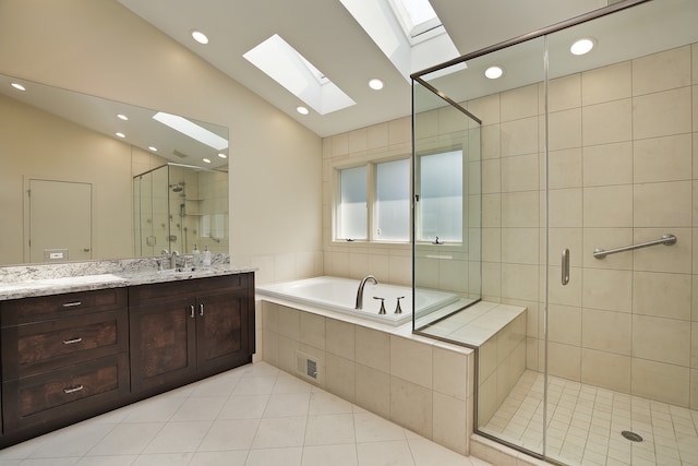 bathroom featuring plus walk in shower, vaulted ceiling with skylight, tile patterned flooring, and vanity