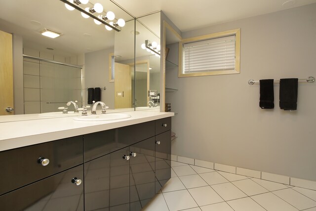 bathroom featuring tile patterned flooring, a shower with door, and vanity