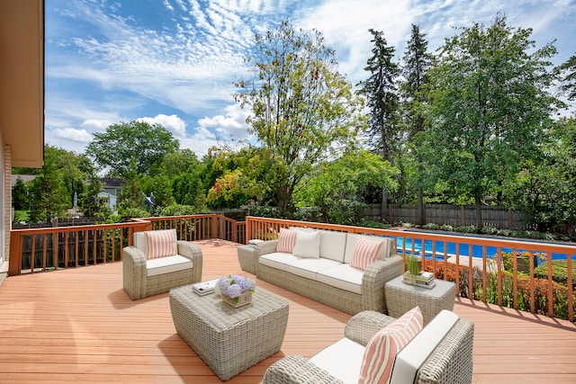 wooden deck with an outdoor living space and a fenced in pool