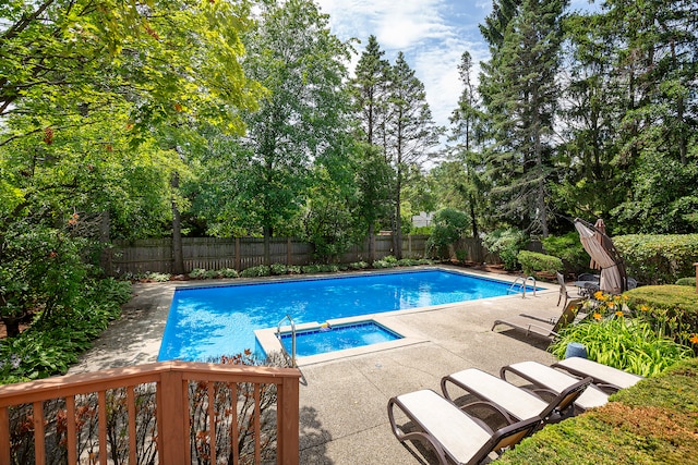 view of swimming pool featuring an in ground hot tub and a patio