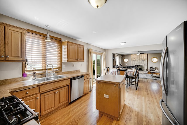 kitchen with a center island, light hardwood / wood-style flooring, appliances with stainless steel finishes, and sink