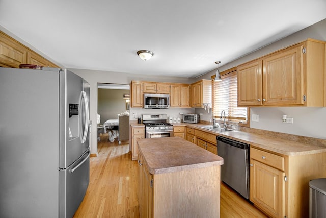 kitchen with sink, decorative light fixtures, a center island, light hardwood / wood-style flooring, and stainless steel appliances