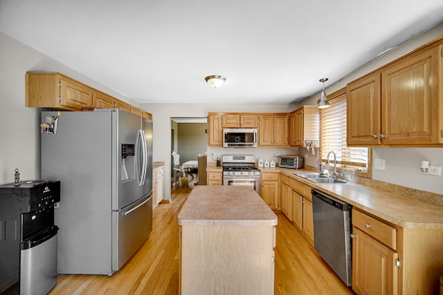 kitchen with a center island, light hardwood / wood-style flooring, appliances with stainless steel finishes, and sink