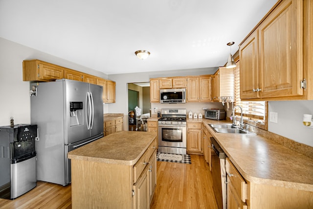 kitchen featuring light hardwood / wood-style flooring, a center island, stainless steel appliances, hanging light fixtures, and sink