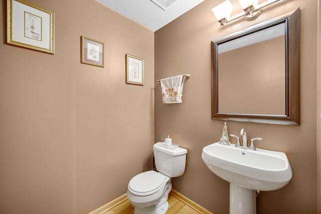 bathroom with hardwood / wood-style flooring and toilet