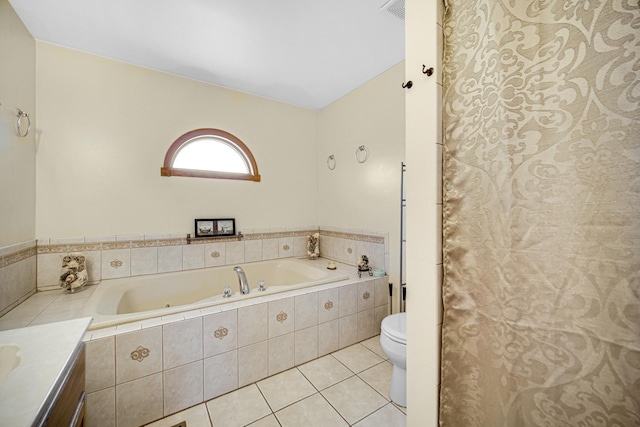 bathroom with tile patterned flooring, vanity, a relaxing tiled tub, and toilet