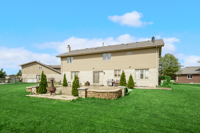 back of house with a patio and a lawn