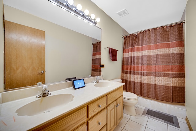 bathroom featuring dual vanity, toilet, and tile patterned flooring