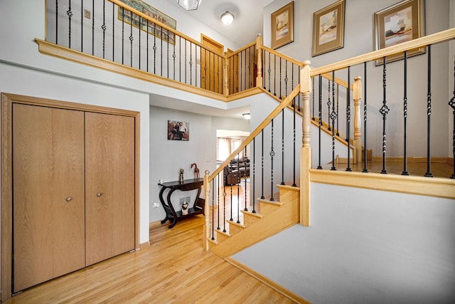 staircase featuring hardwood / wood-style floors and a high ceiling