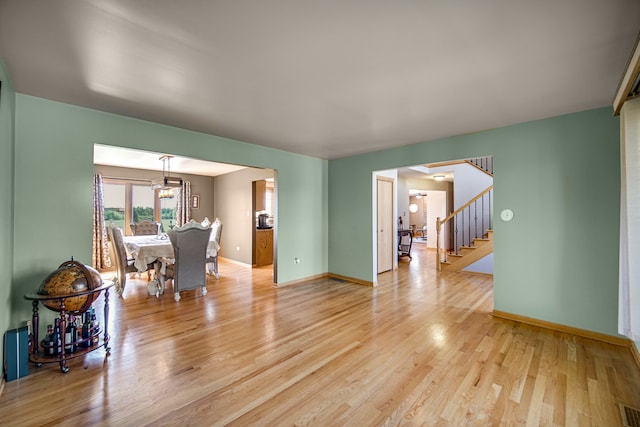 unfurnished living room featuring wood-type flooring and a chandelier