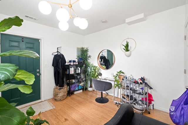 exercise room featuring hardwood / wood-style flooring and a notable chandelier