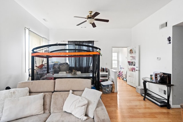 living room with light wood-type flooring and ceiling fan