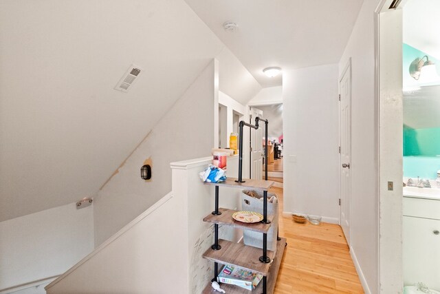 hall with hardwood / wood-style flooring and lofted ceiling