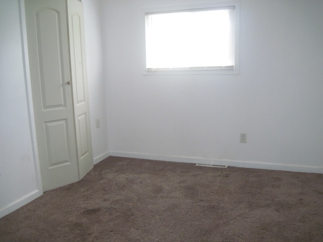 empty room with dark colored carpet