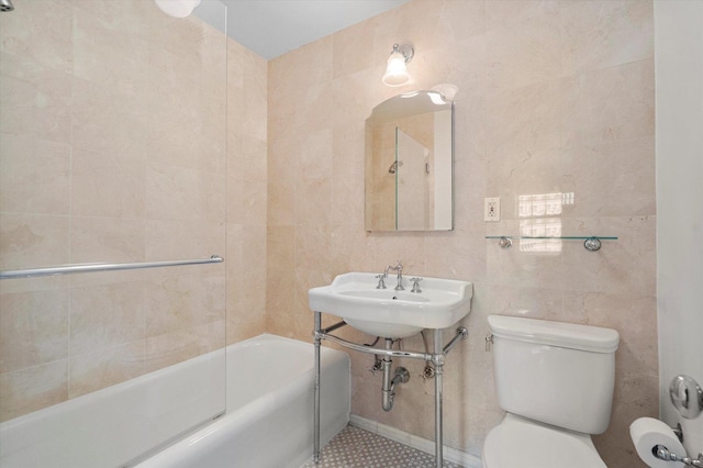 bathroom featuring toilet, tile walls, and shower / bathing tub combination