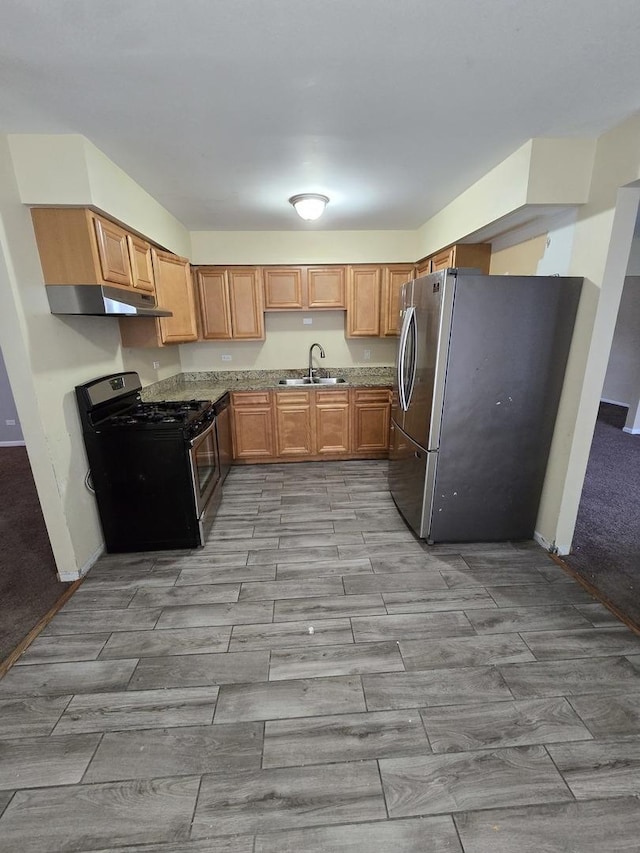 kitchen with stainless steel fridge, black gas range, and sink