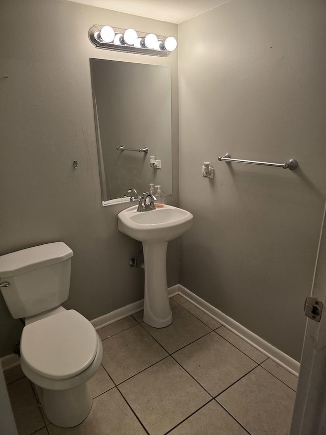 bathroom with tile patterned flooring, toilet, and sink