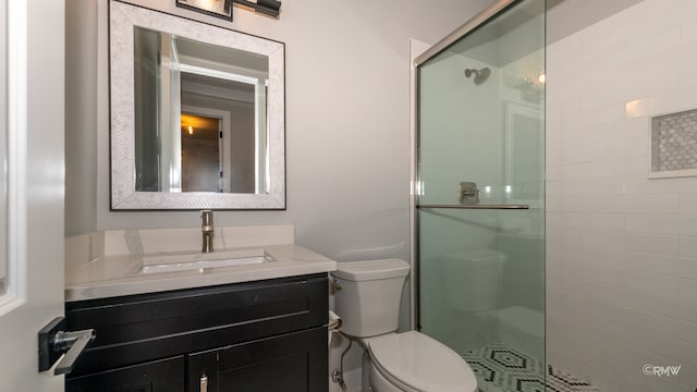 bathroom featuring toilet, a shower with door, and vanity