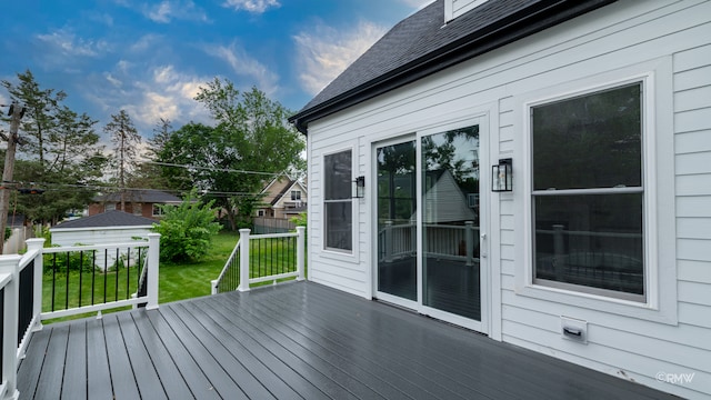 wooden deck featuring a lawn and an outdoor structure