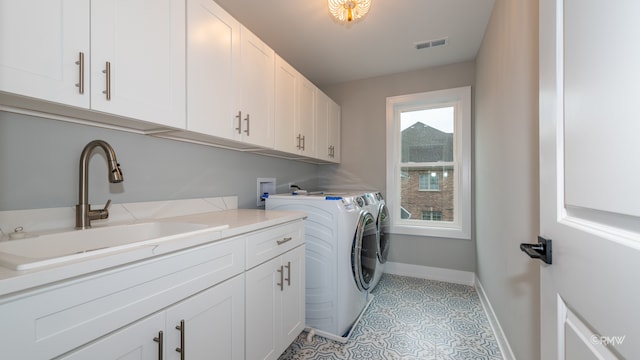 laundry area with light tile patterned floors, sink, cabinets, and washing machine and dryer