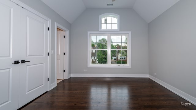 unfurnished room with dark wood-type flooring and vaulted ceiling