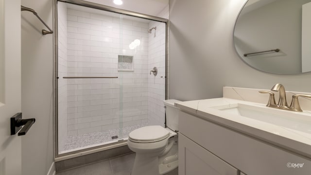 bathroom featuring tile patterned flooring, vanity, toilet, and an enclosed shower