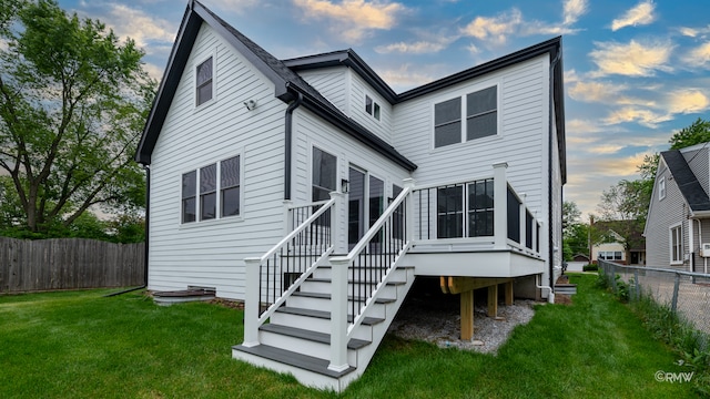 rear view of property featuring a yard and a wooden deck