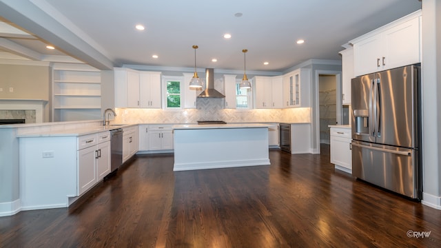 kitchen featuring decorative light fixtures, dark hardwood / wood-style flooring, stainless steel appliances, white cabinetry, and wall chimney range hood