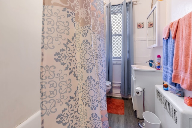 full bathroom featuring wood-type flooring, shower / bath combination with curtain, toilet, and vanity