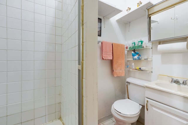 bathroom with vanity, a tile shower, and toilet