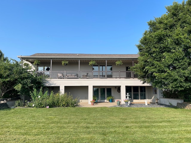 rear view of property featuring a yard and a balcony