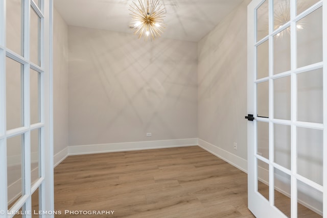 spare room featuring hardwood / wood-style flooring and french doors