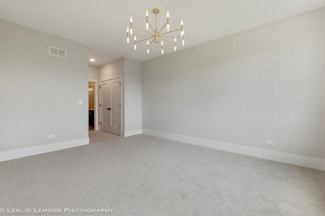 unfurnished room with a notable chandelier and carpet flooring