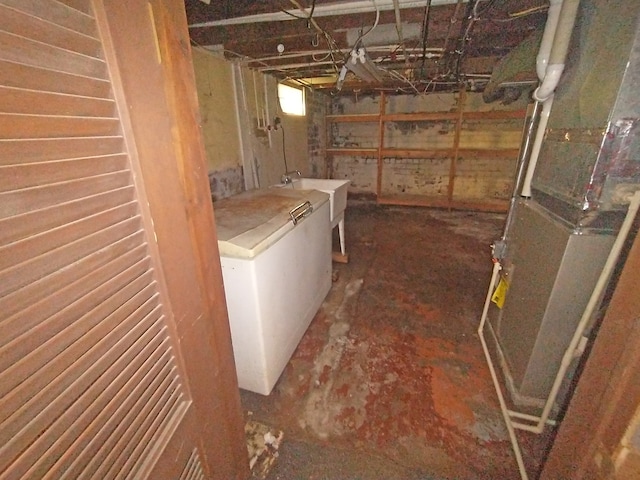 basement with washer / dryer, sink, and heating unit