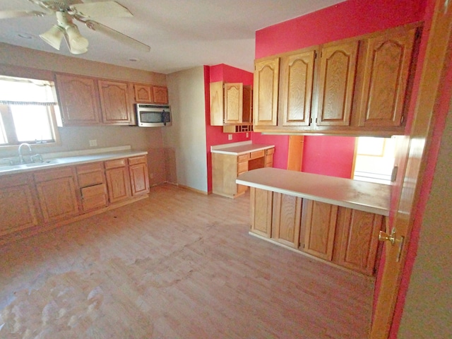 kitchen featuring sink, kitchen peninsula, a healthy amount of sunlight, and ceiling fan