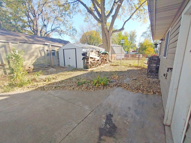 view of yard featuring a storage shed and a patio