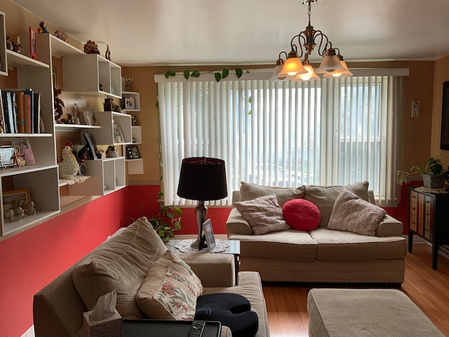 living room featuring plenty of natural light, an inviting chandelier, and wood-type flooring