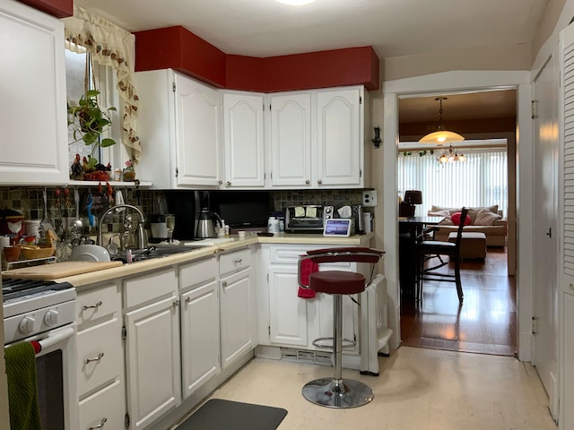 kitchen featuring range, white cabinetry, tasteful backsplash, and light wood-type flooring