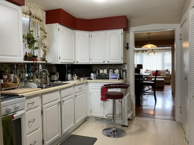 2323 N Keating Ave, Chicago, IL 60639 - kitchen featuring backsplash, a sink, and white cabinets