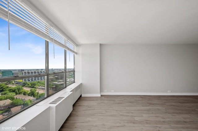 unfurnished room with radiator and hardwood / wood-style flooring