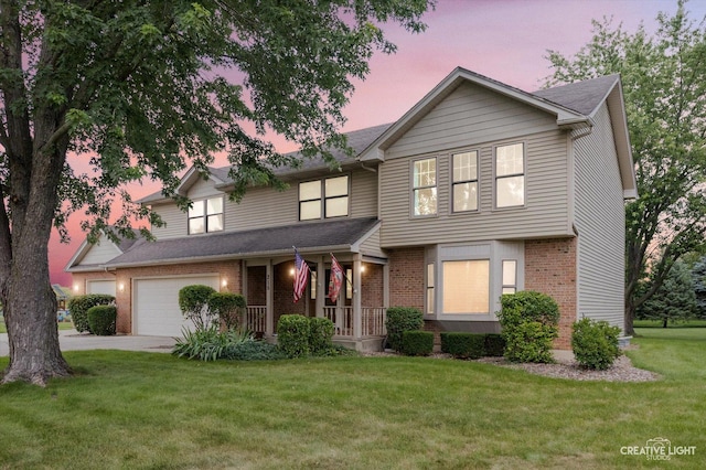 view of front of house with driveway, a front lawn, a porch, an attached garage, and brick siding