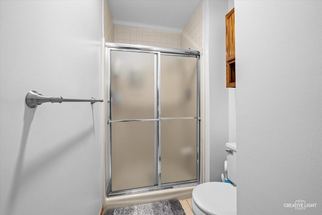 bathroom with toilet and an enclosed shower