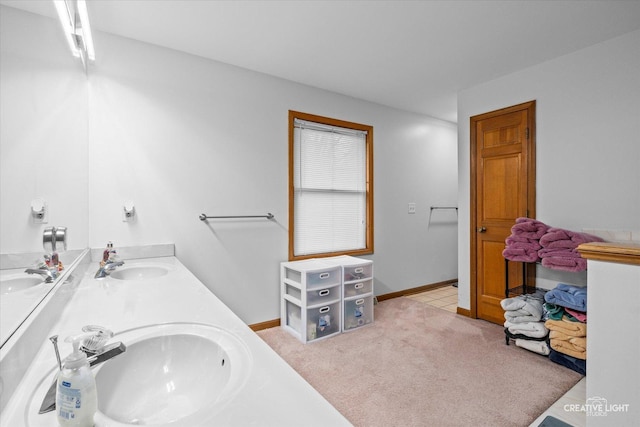 bathroom featuring double vanity, baseboards, and a sink