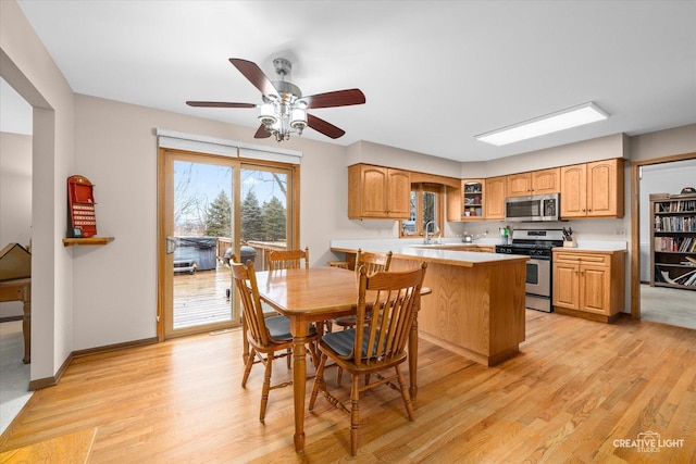 dining room with a ceiling fan, light wood-type flooring, and baseboards