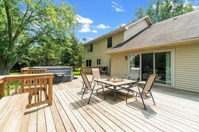 wooden terrace featuring a fire pit and a hot tub